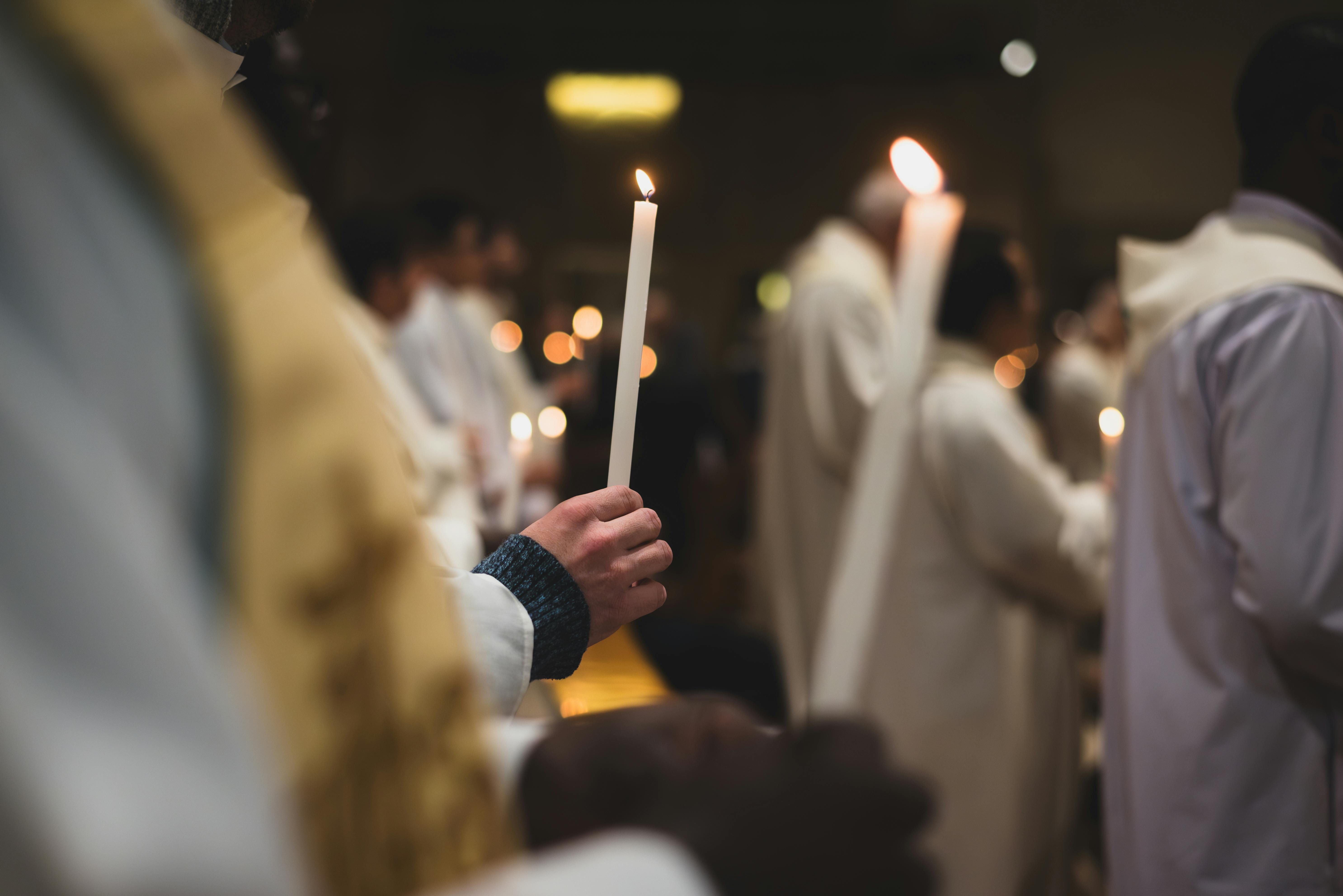 Parishioners holding candles in prayer.